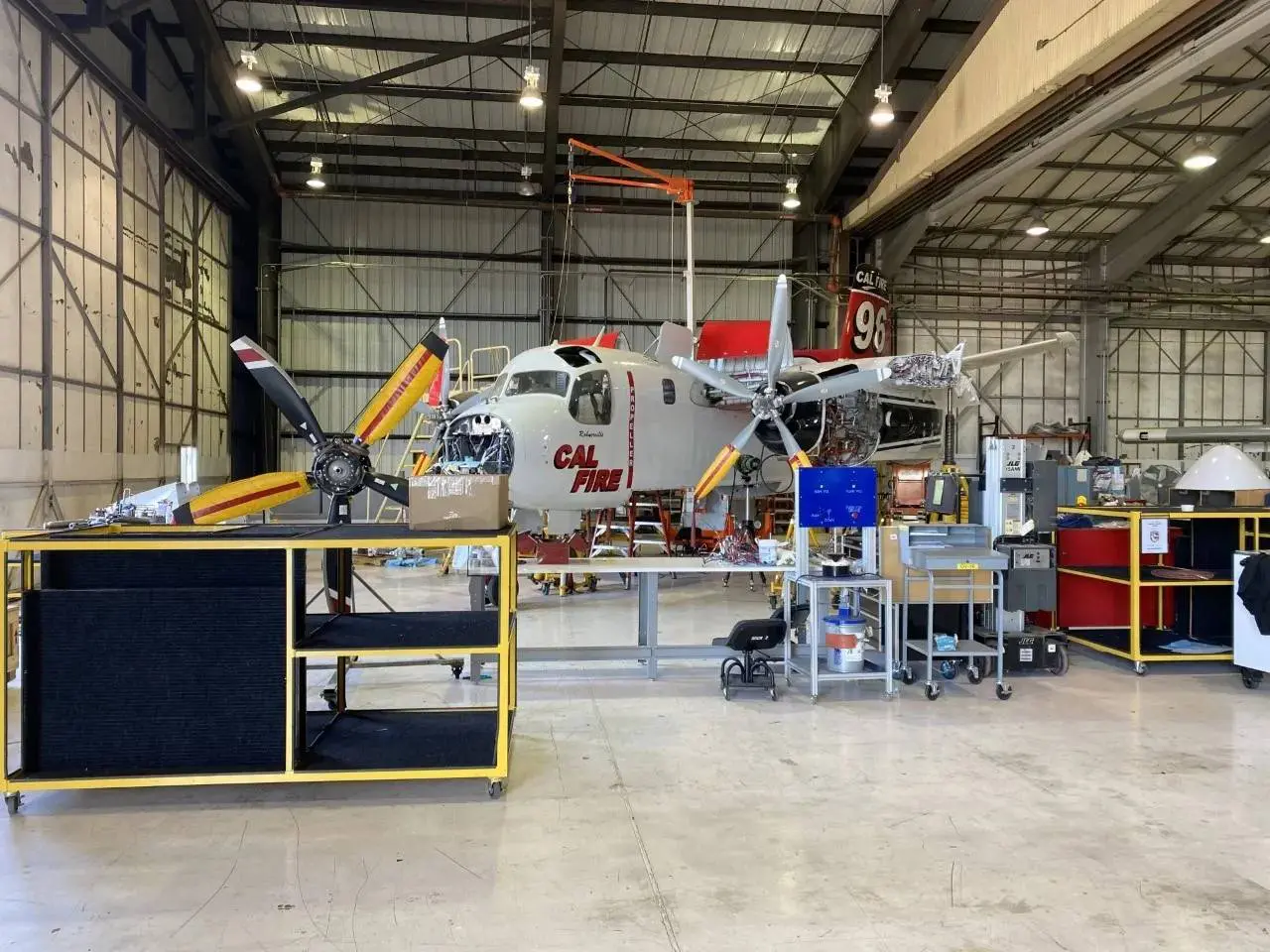 A hangar with a plane in it and some work equipment.